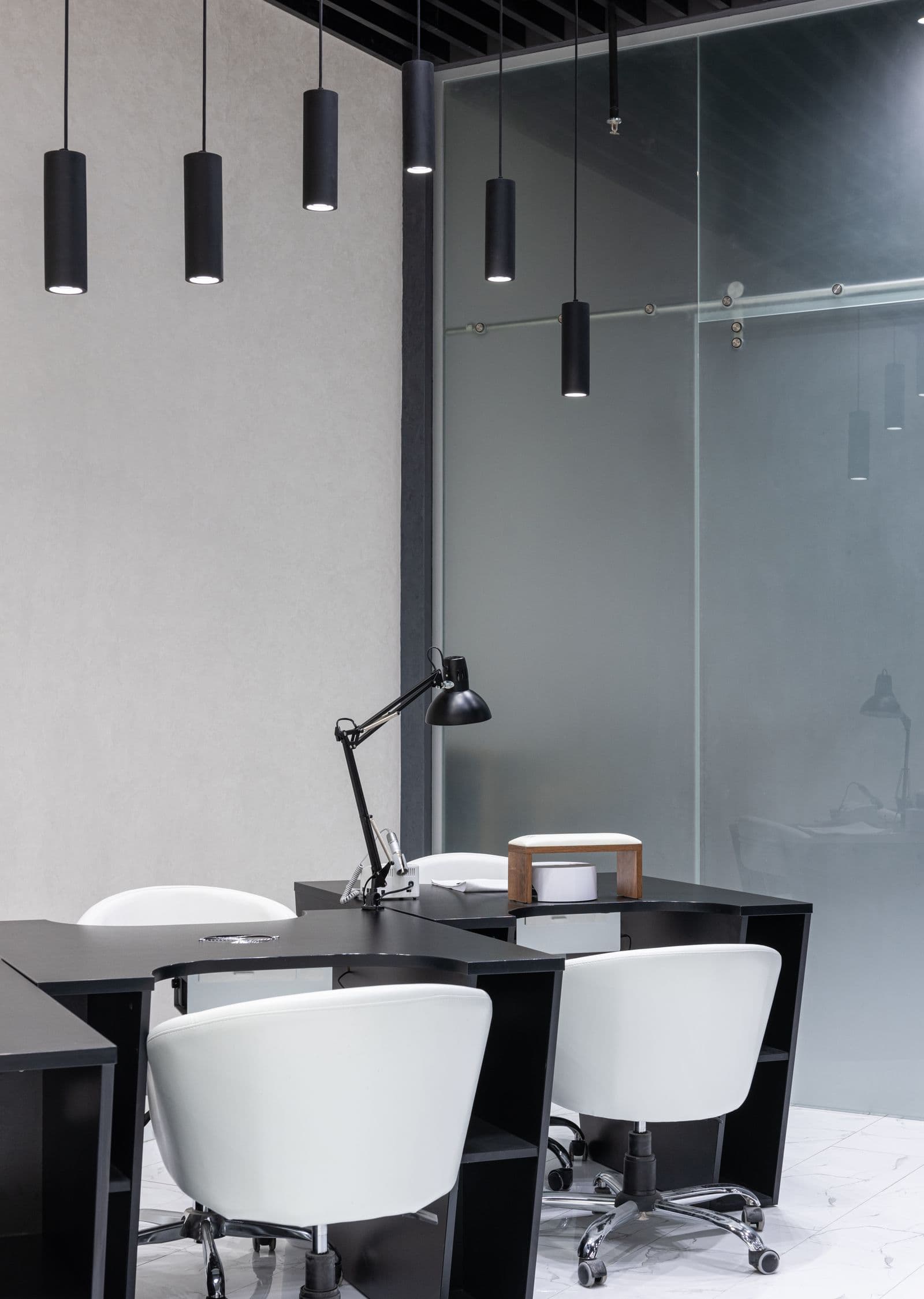 Interior de escritório moderno com mobiliário escuro e luminárias pendentes