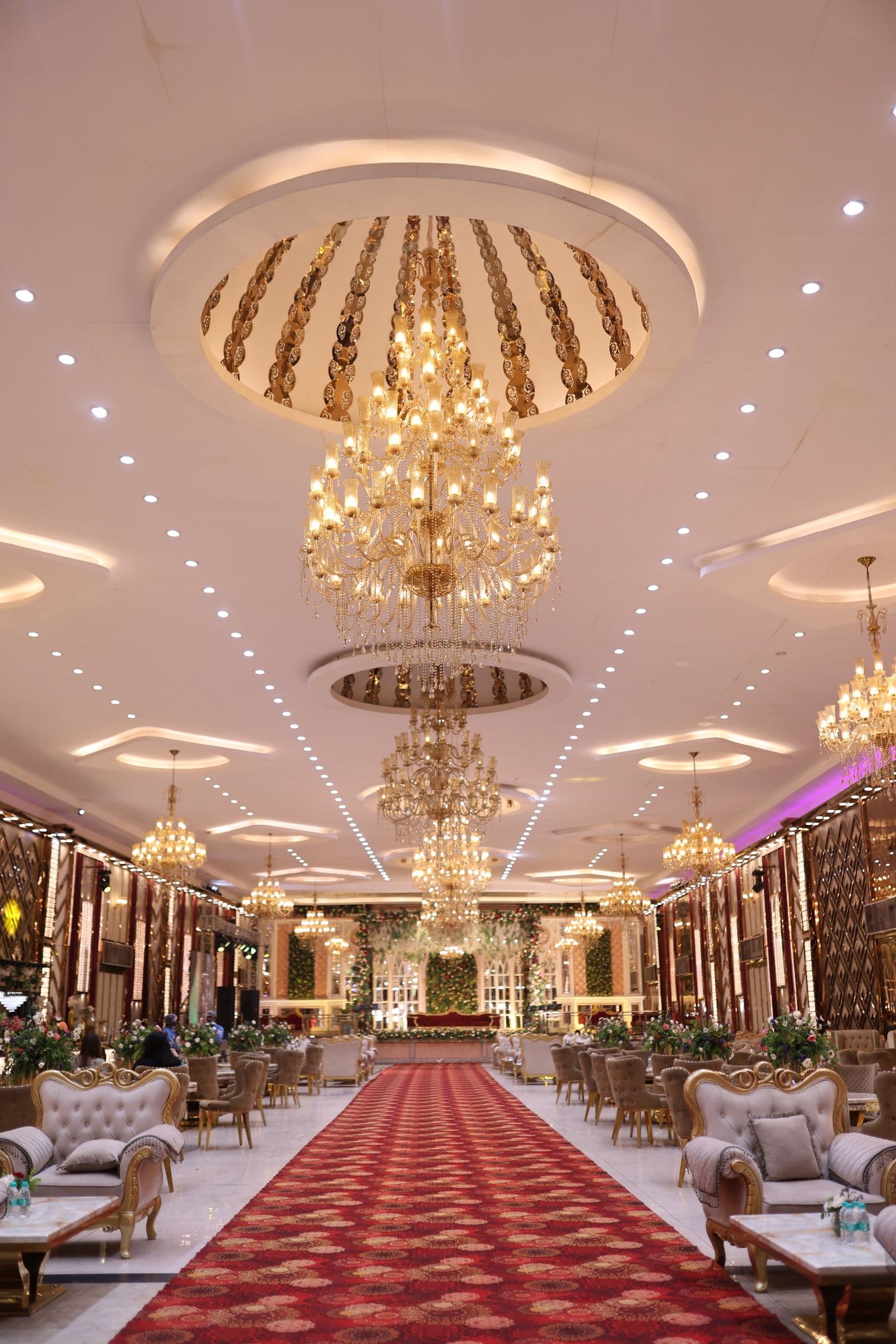 Salão de festas decorado para recepção de casamento, com mesas e lustres